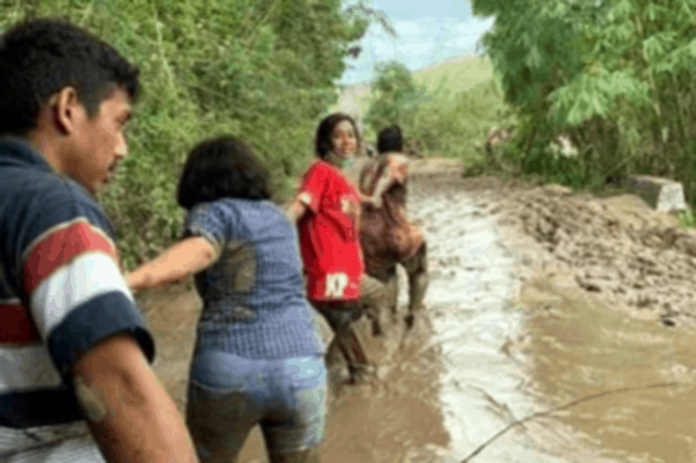 Merliaty Praing Simanjuntak saat menerobos lumpur menuju Desa Kiritana, Kecamatan Kambera, Kabupaten Sumba Timur, Selasa 6 April 2021.