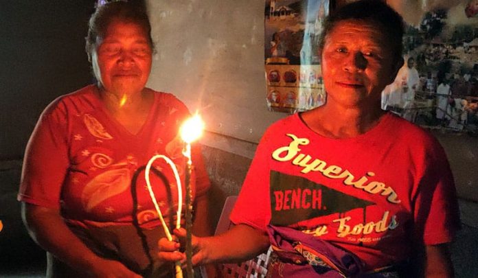 Dua ibu di Mirekpuka memperlihatkan lampu pelita yang terbuat dari kapas dan kemiri.