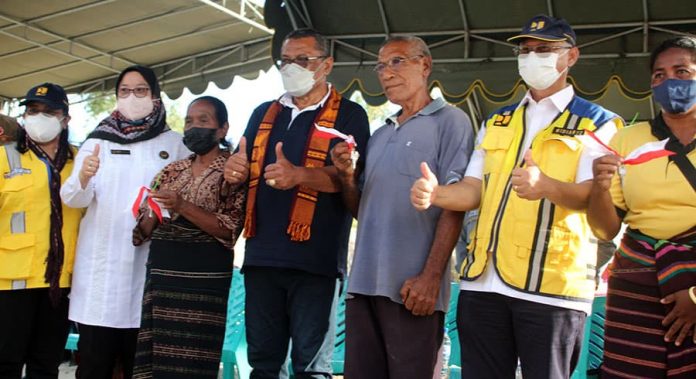 Inspektur Jenderal Kementerian PUPR, Widiarto, dan Bupati Kabupaten Lembata, Thomas Ola Langoday, foto bersama lima orang perwakilan warga terdampak yang menerima kunci rumah.