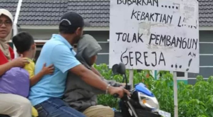 Pembangunan Gereja Ditolak, Inikah Toleransi? Penduduk di Bekasi melewati tulisan tolak pembangunan gereja di dekat GPIB Filadelfia, Bekasi, yang disegel pada 25 Desember 2012.